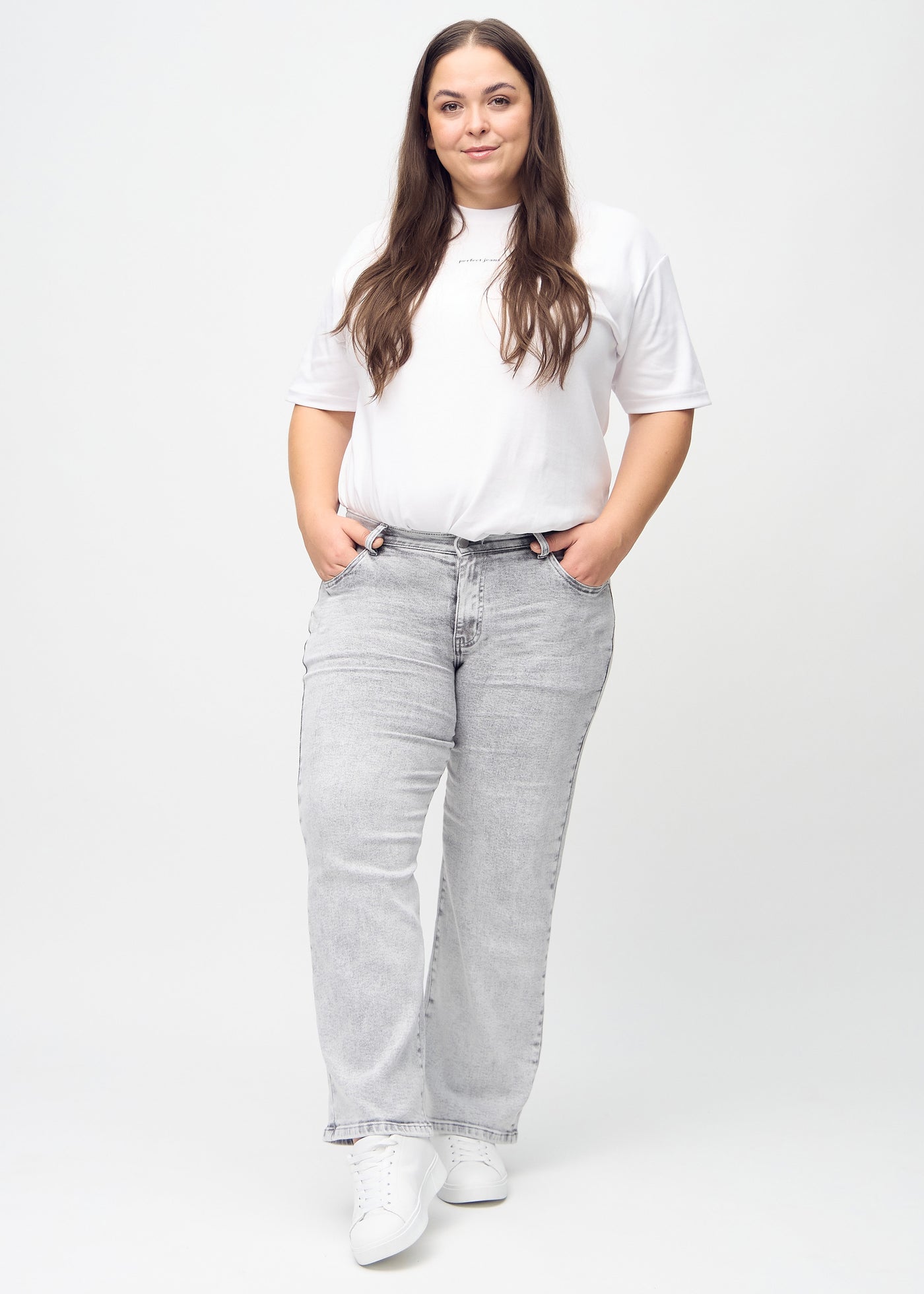 Fuldt billede af en plus-size model i lysegrå denim loose jeans.