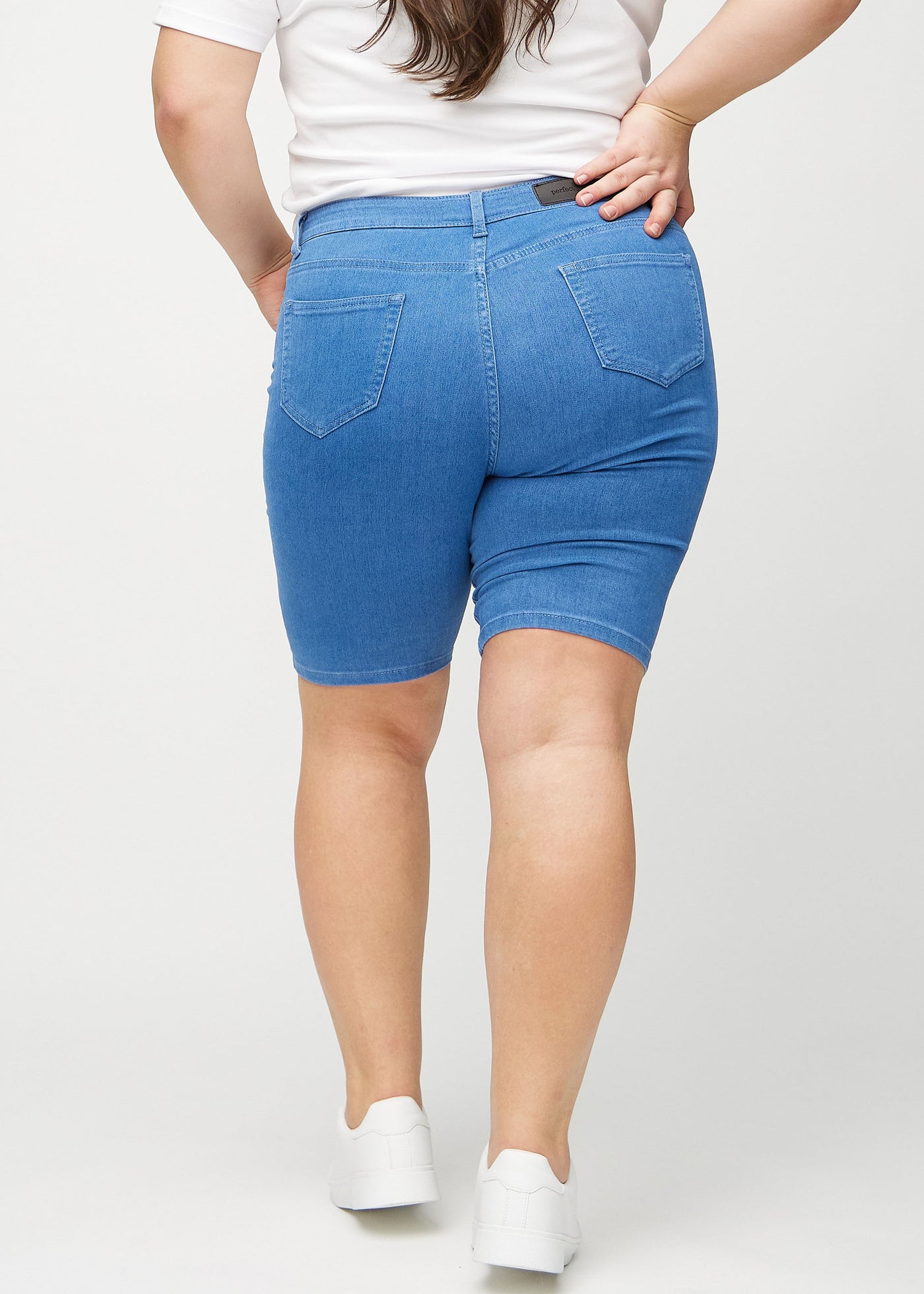 Blå skinny middle shorts set bagfra på en plus-size model, så man kan se hele produktet.