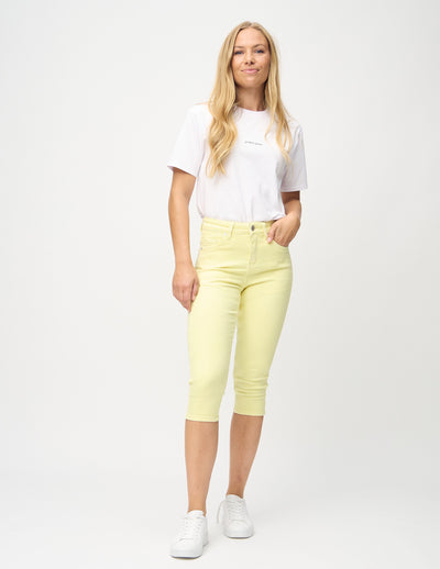 Fuldt billede af model i lysegule skinny capris.