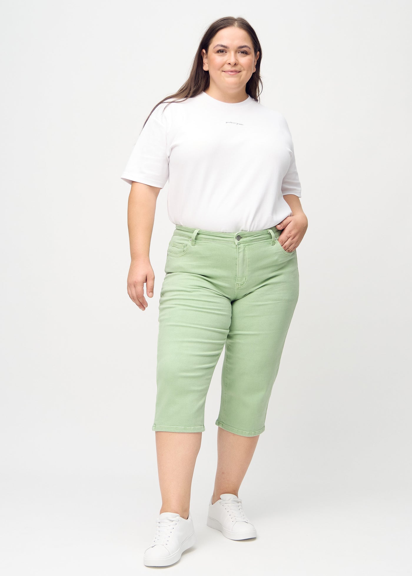 Fuldt billede af en plus-size model i lysegrønne regular capris.