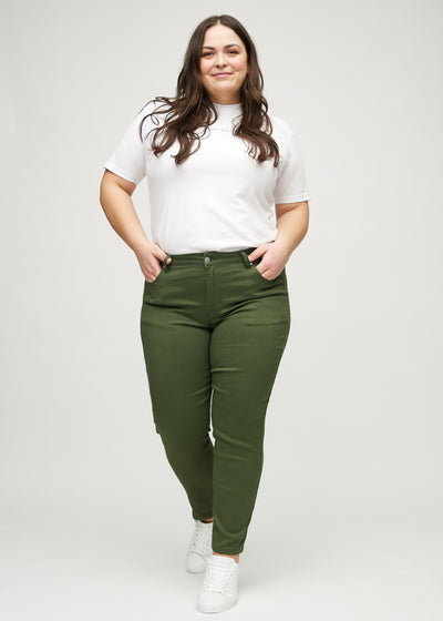 Fuldt billede af en plus-size model i mørkegrønne slim jeans.