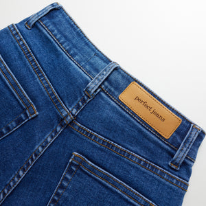 Bagsiden af et par mørkeblå denim jeans, hvor man klan se Perfect Jeans logoet.