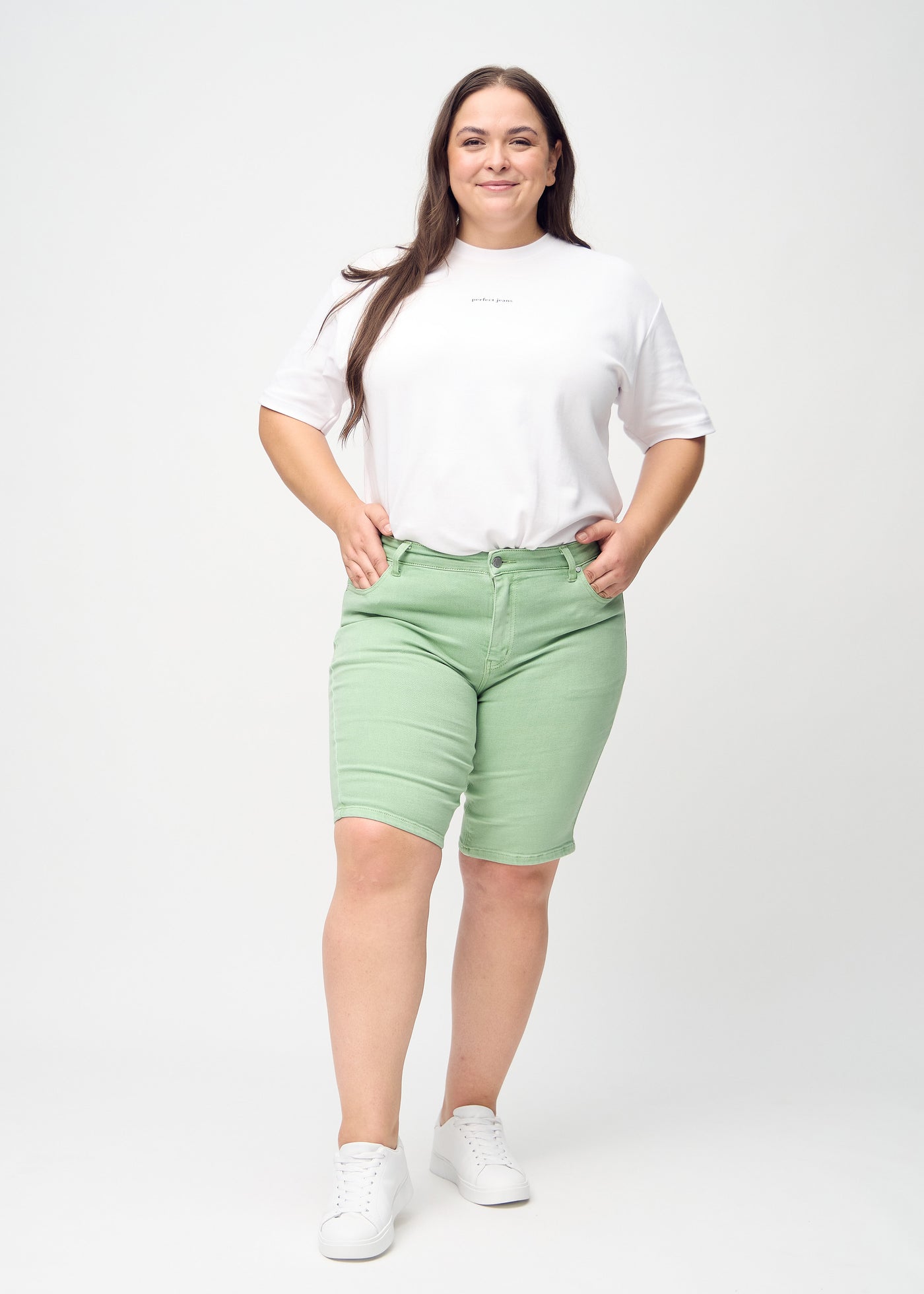 Plus-size model går ind i billedet, strækker i sine shorts, viser dem frem ved at dreje rundt, og forlader derefter billedet.